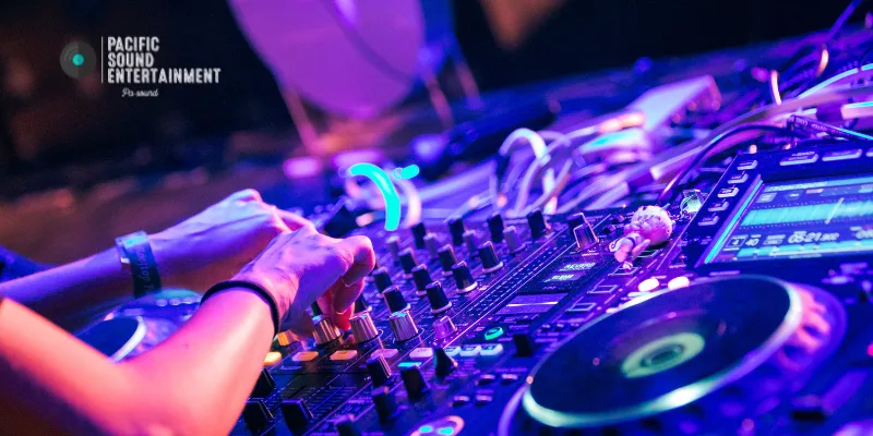 Professional DJ mixing tracks on Rekordbox with colorful waveforms displayed.