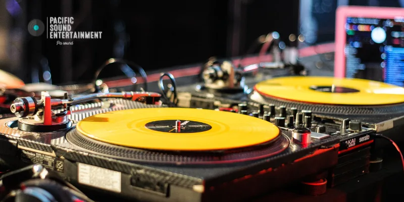 Turntables setup with Serato DJ software running on a laptop in the background.